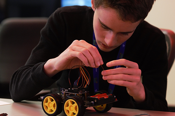 A young STEM student working on a robot