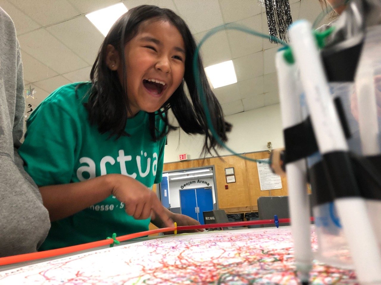 Smiling young girl participating in STEM event, hosted by Actua