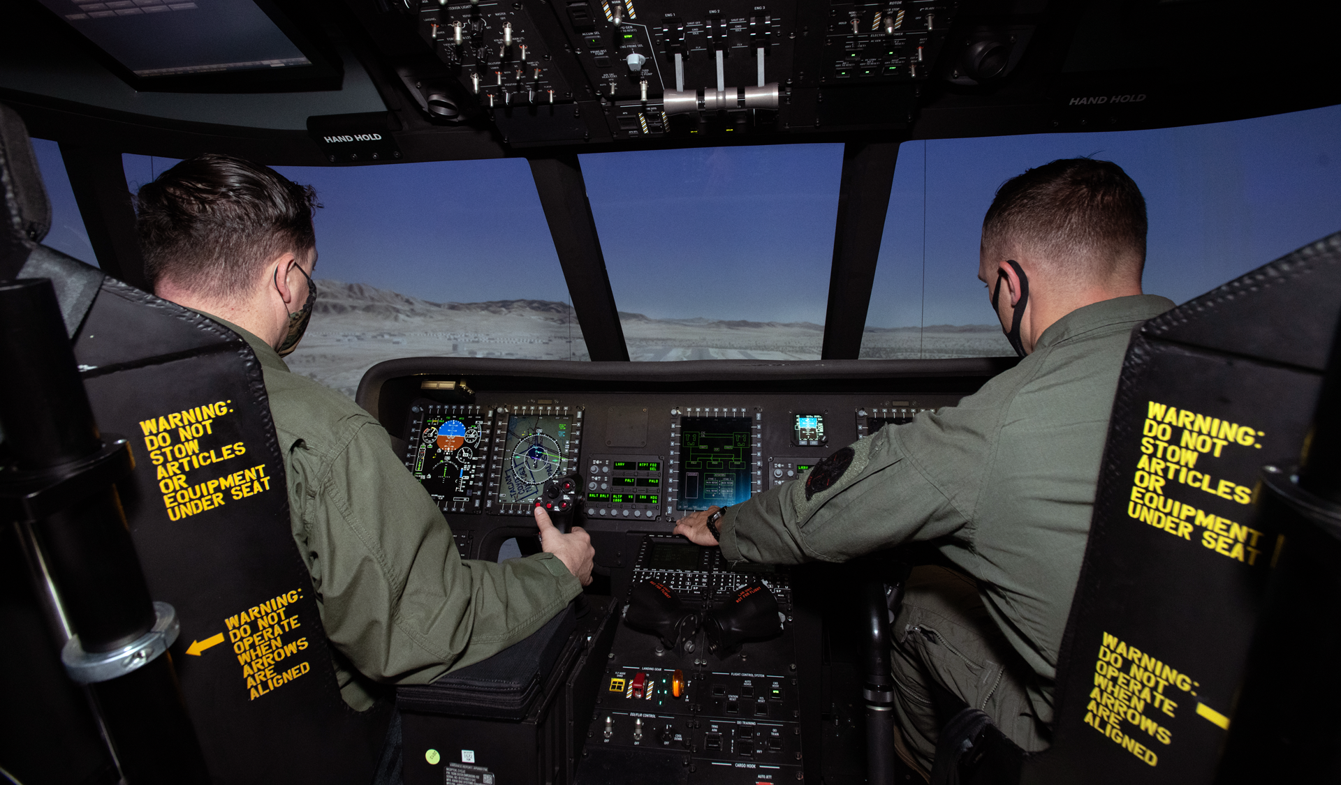 Marine Corps CH-53K test pilots Capt. Nick Moran and Lt.Col. Kelly Atwood in the CH-53K Containerized Flight Training Device (CFTD) experience a highly immersive virtual environment.