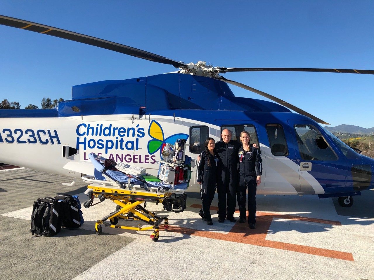 The pilot and medical crew pose for a photo in front of the CHLA helicopter. The S-76’s large size allows plenty of room for a parent, medical crew, and even a full-sized gurney. Photo provided.