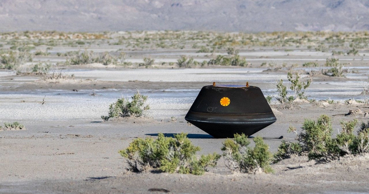 The OSIRIS-REx sample return capsule rests on the ground in the Utah desert