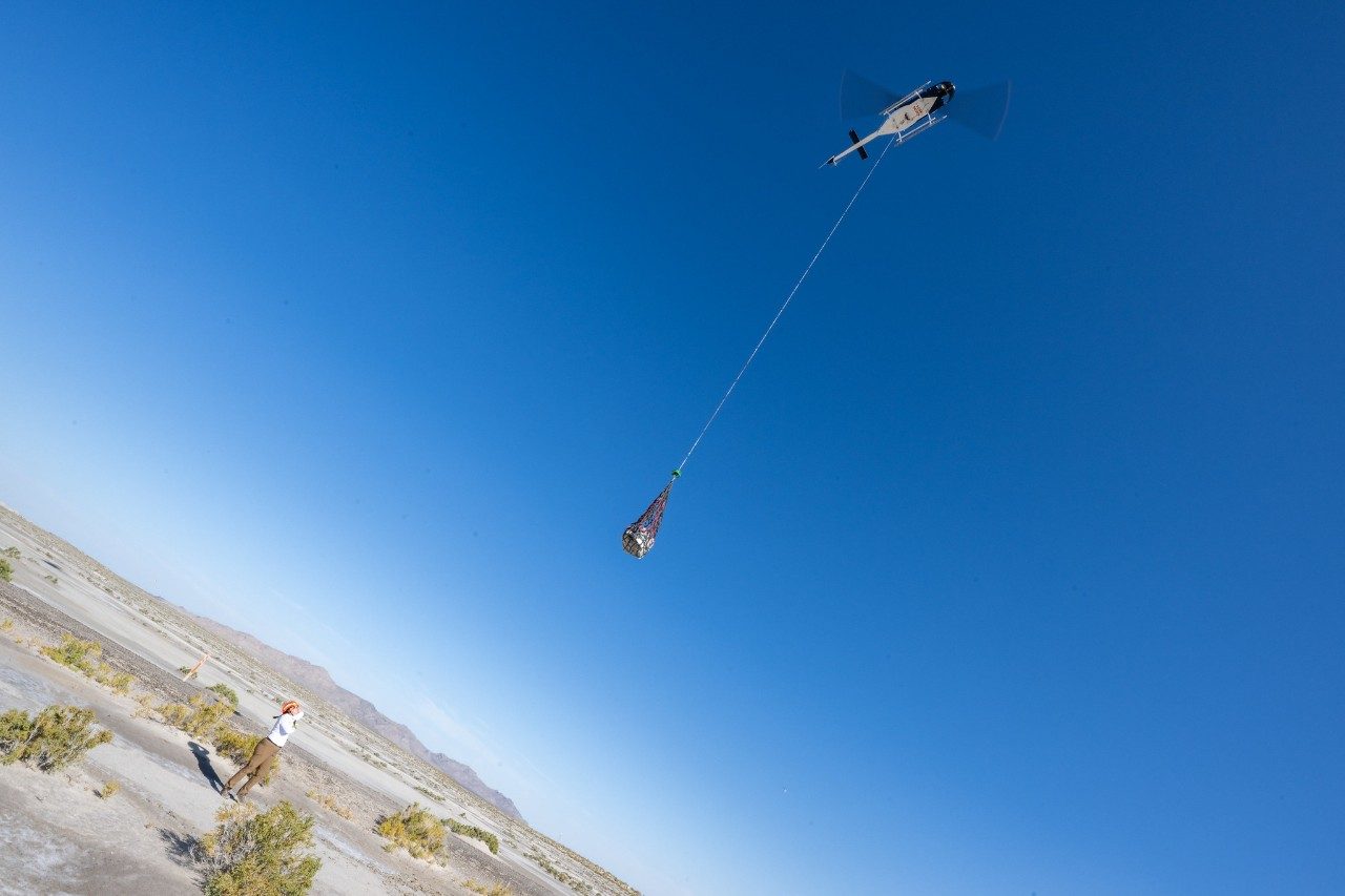 The OSIRIS-REx sample return capsule is airlifted from its landing site in the Utah desert
