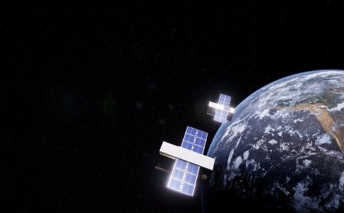 Two vanguard satellites flying over earth