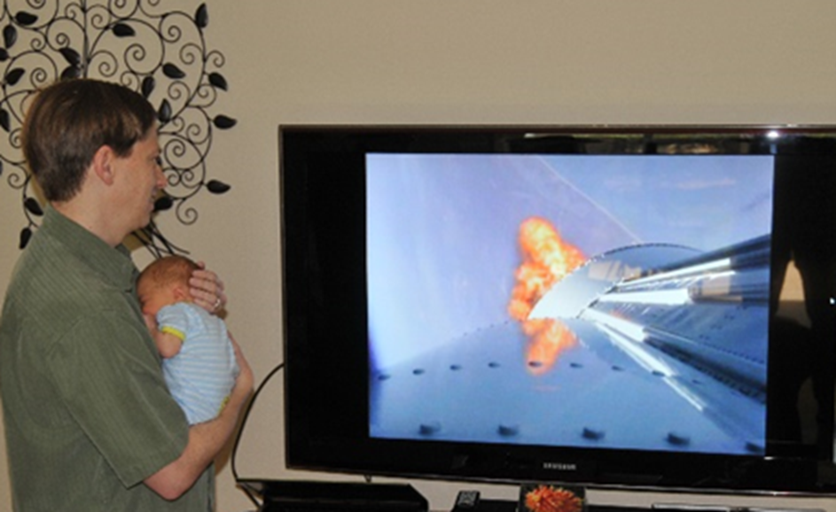 Johnathon Caldwell holding his newborn son as he watches the launch of SBIRS GEO-1 in 2011